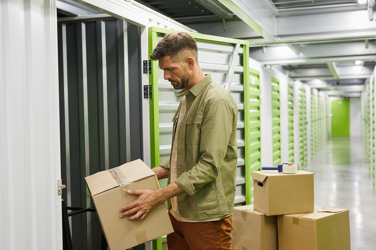 man putting boxes in a storage unit