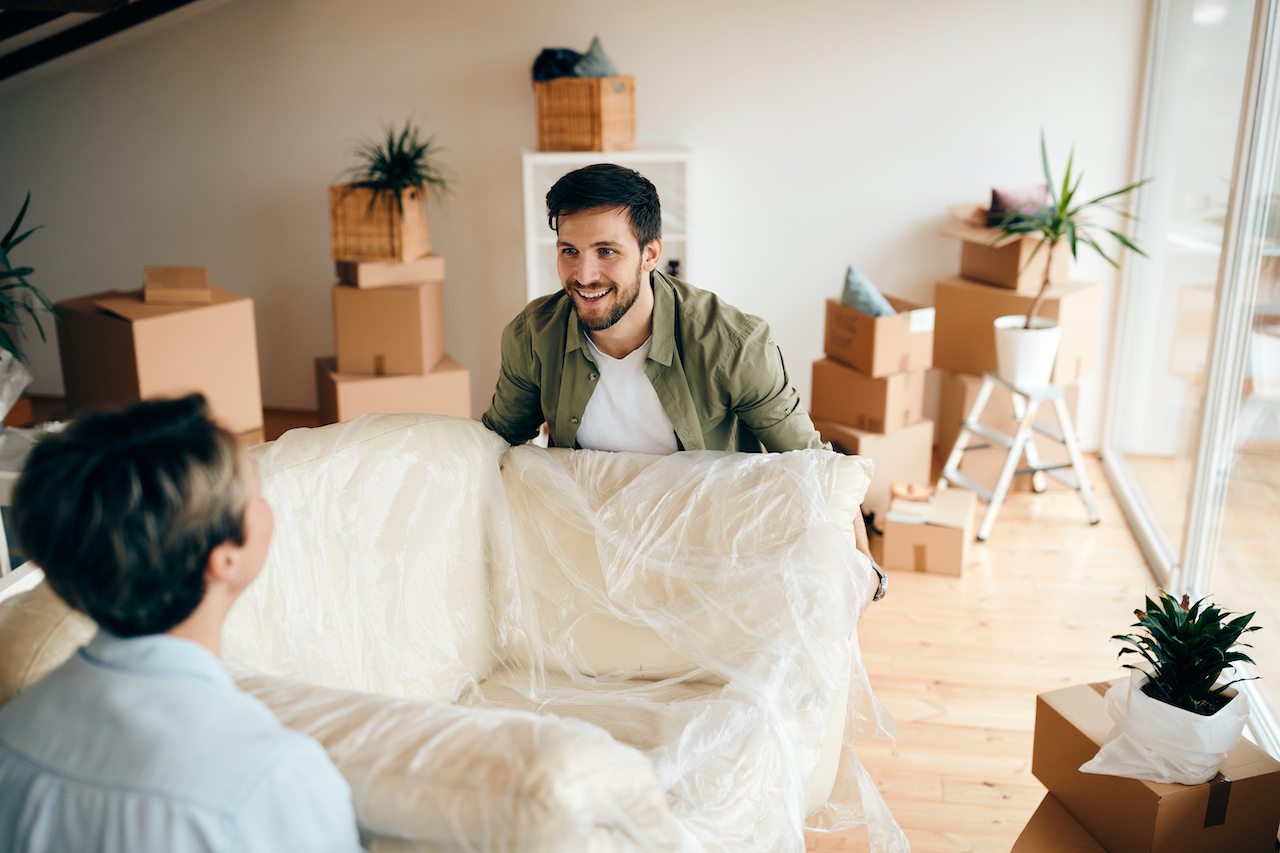 couple carrying furniture to store in a drive up storage unit