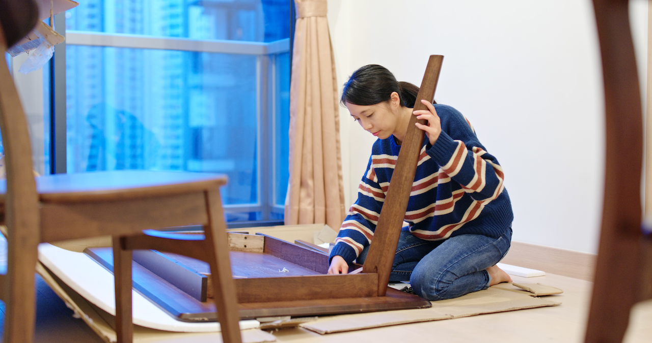 woman preparing wooden table for furniture storage