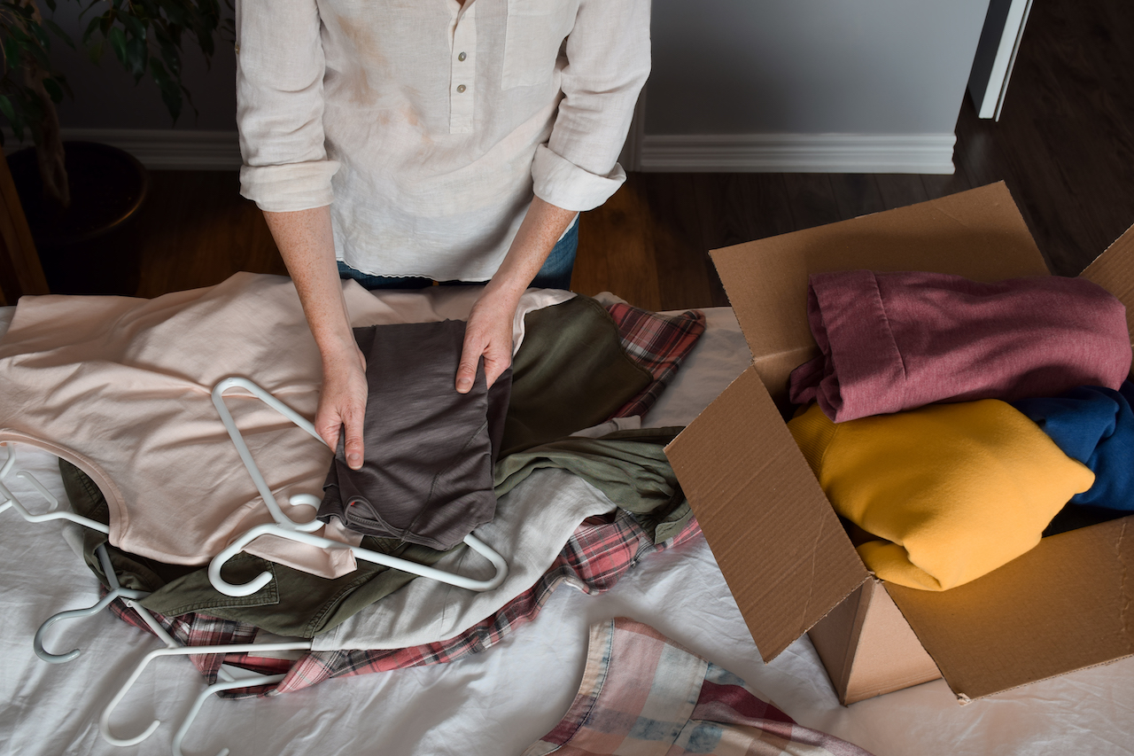 person going through clothes for storage