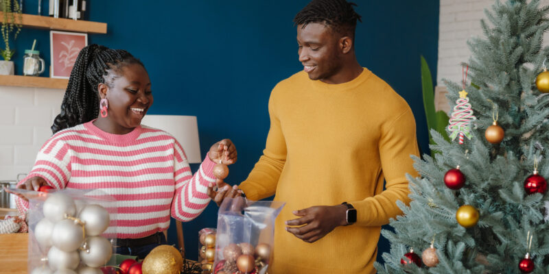 A young couple puts Christmas decorations into storage